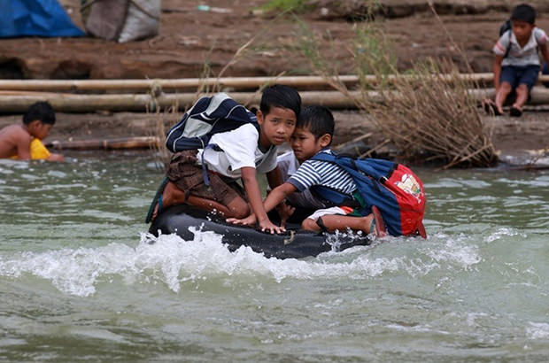 Elementary school students of this remote village make a river crossing on inflated tire tubes