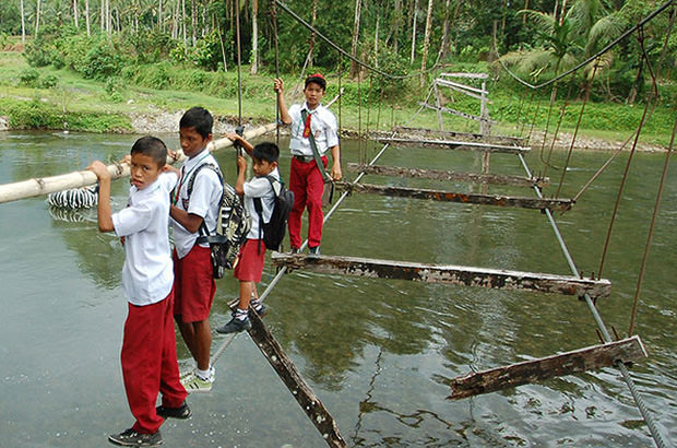 School children cross this bridge that was stripped bare following an earthquake