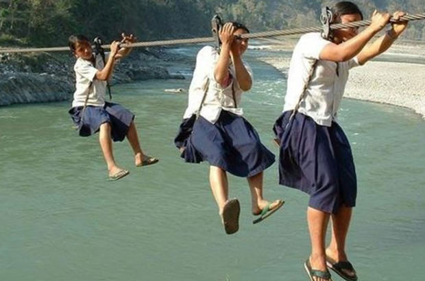 School children in Nepal use makeshift ropes and pulleys to get across ravines to get to school